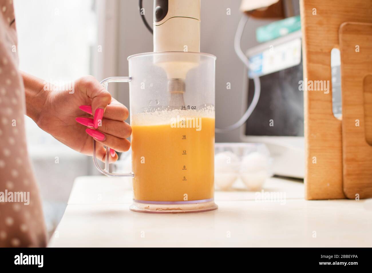 Girl whips raw eggs in a blender Stock Photo Alamy