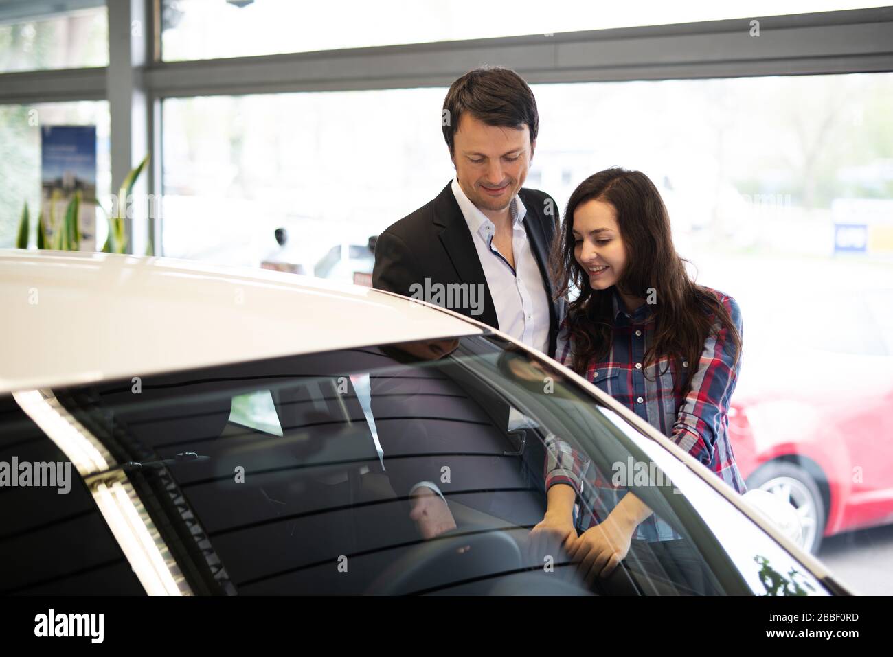 Car salesman shows a customer a new car Stock Photo