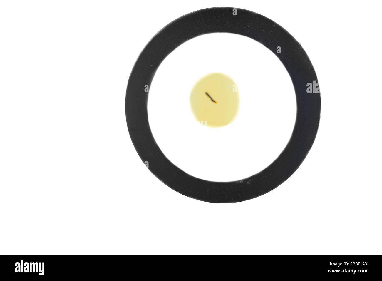 Unlit candle on a black holder, seen from above. Stock Photo