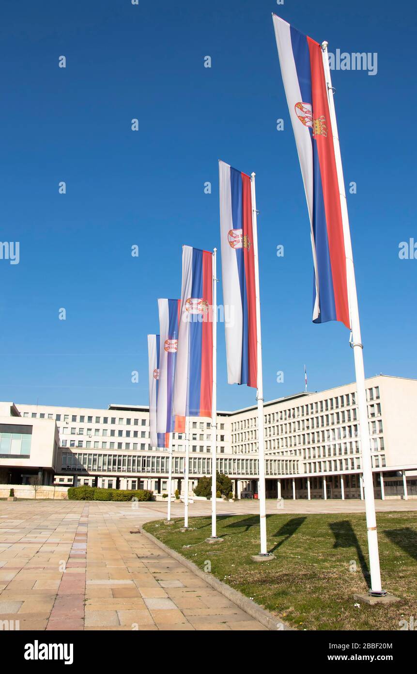 Belgrade, Serbia - March 20, 2020: Serbian national flags on poles in front of the Palace of Serbia, governmental building completed in 1951, the larg Stock Photo