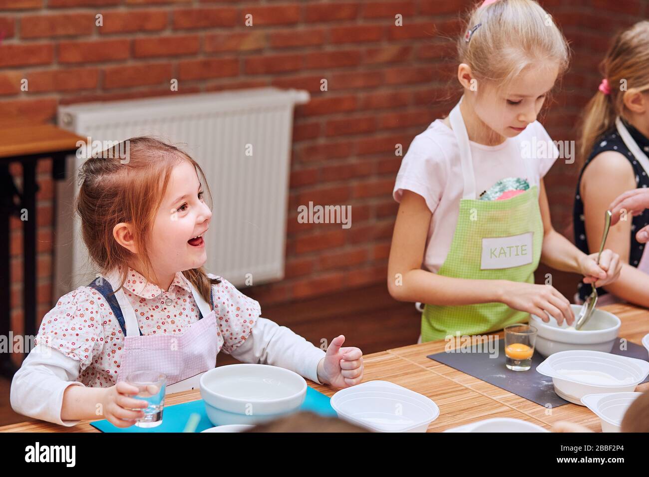 Little girls combining the ingredients for baking the cake. Kids taking