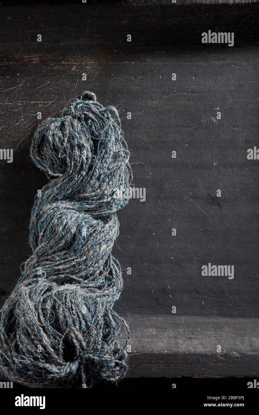 home spun yarn wool rough raw stone table Stock Photo