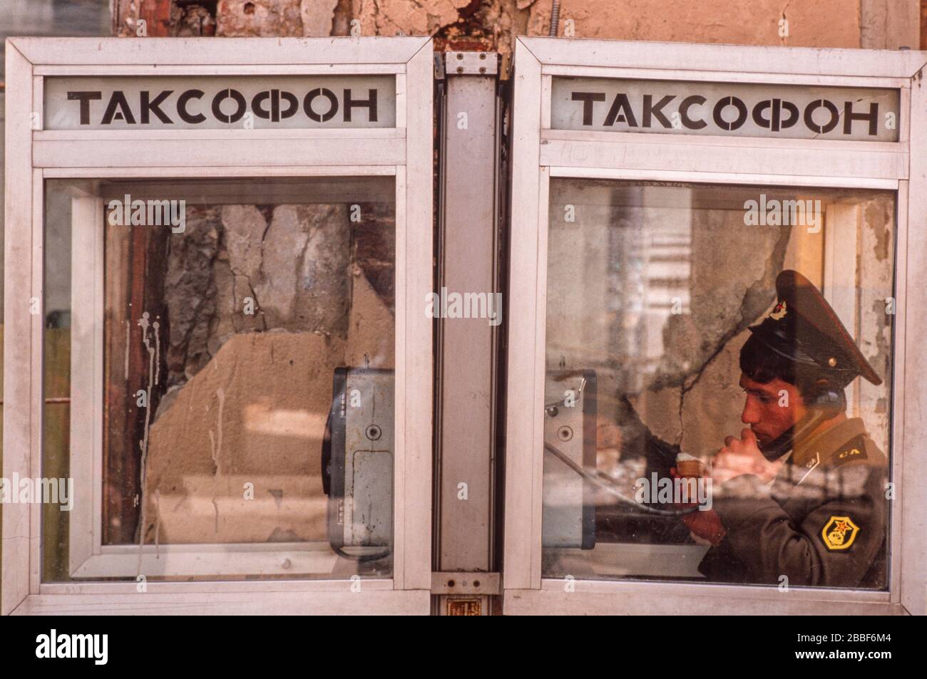 A young Russian soldier makes a phone call while eating an ice cream, Moscow, May 1990 Stock Photo