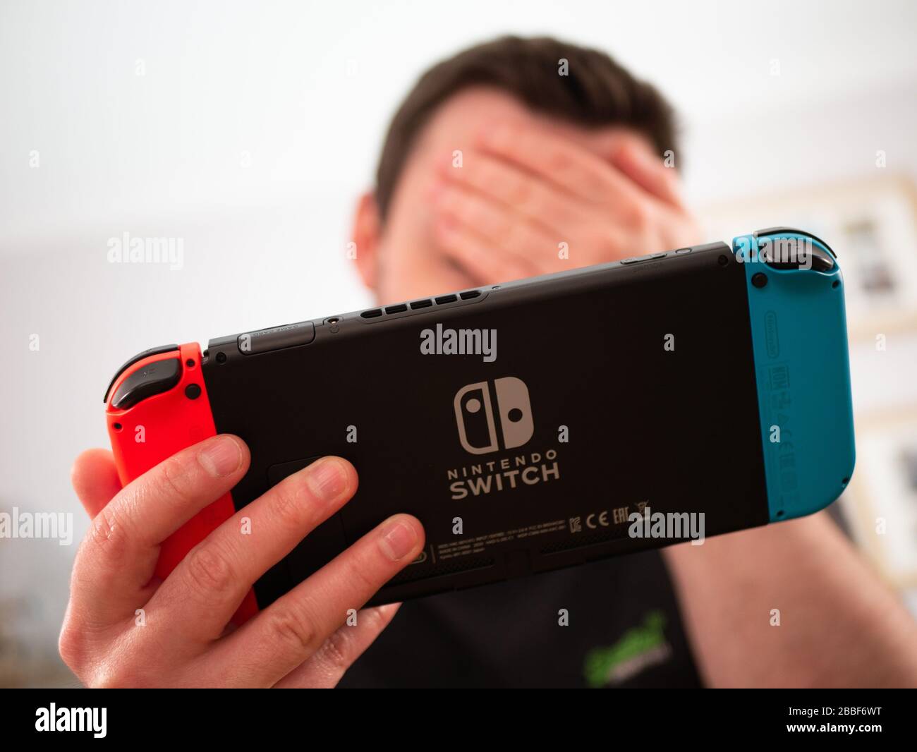UK, March 2020: Nintendo Switch games console player losing disappointed with head in hands Stock Photo