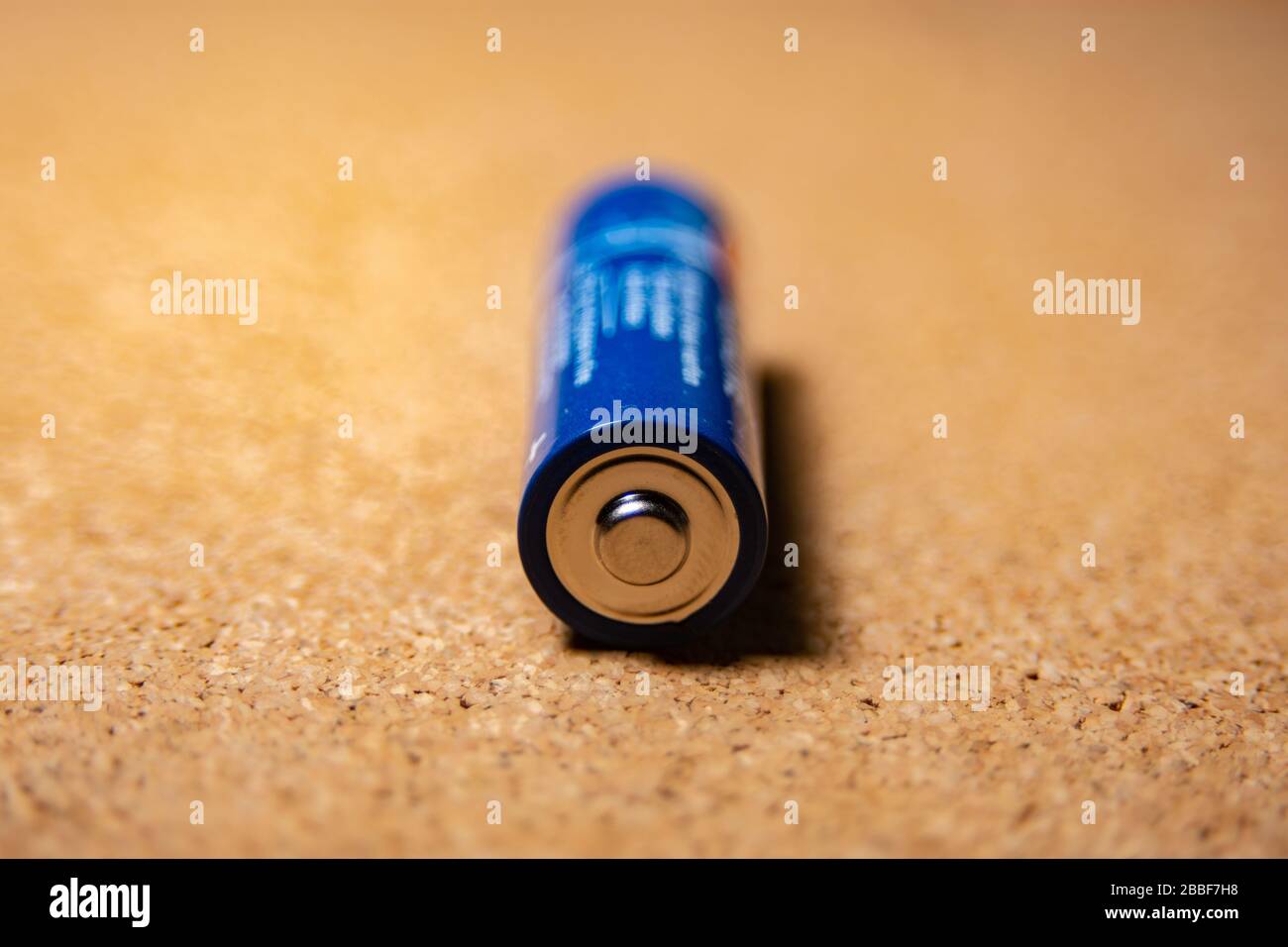 blue battery lying positive on the cork board Stock Photo - Alamy