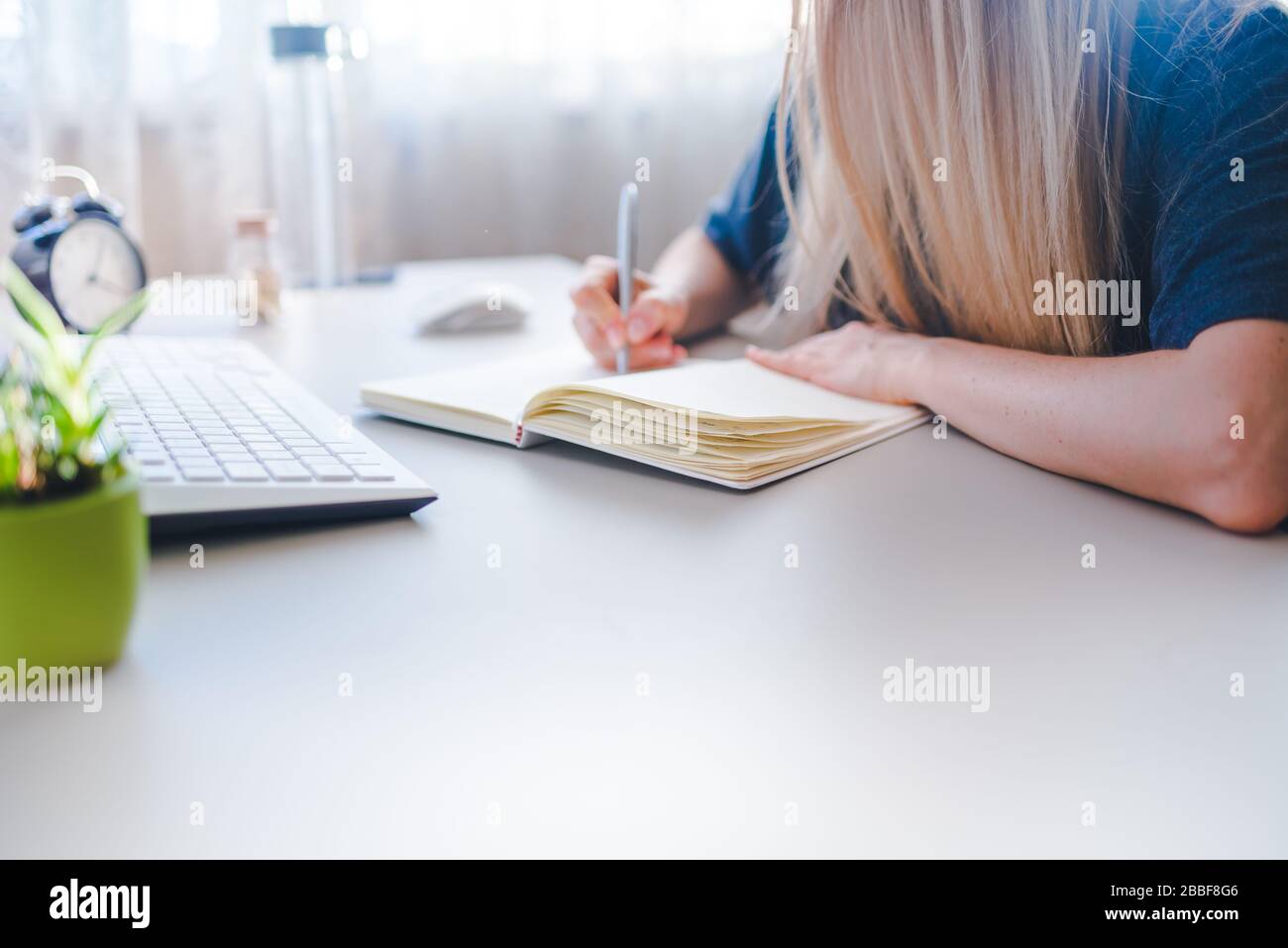 Girl Writing A Routine girl writes in notebook, draws up a schedule for the week Stock Photo ...