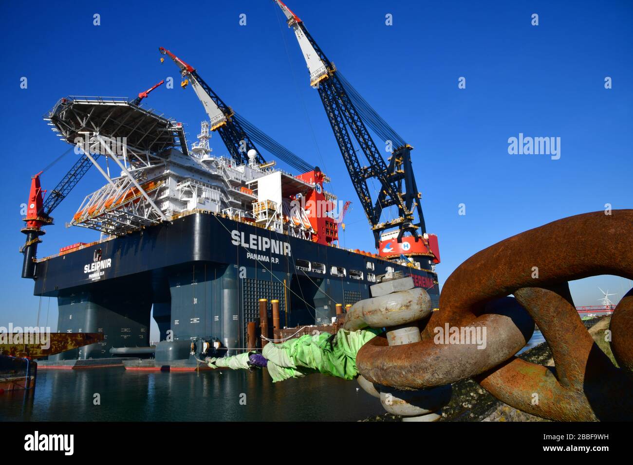 Rotterdam, The Netherlands-March 2020: Close up view along giant shackles on docked offshore platform, largest crane vessel in the world (Sleipnir) wi Stock Photo