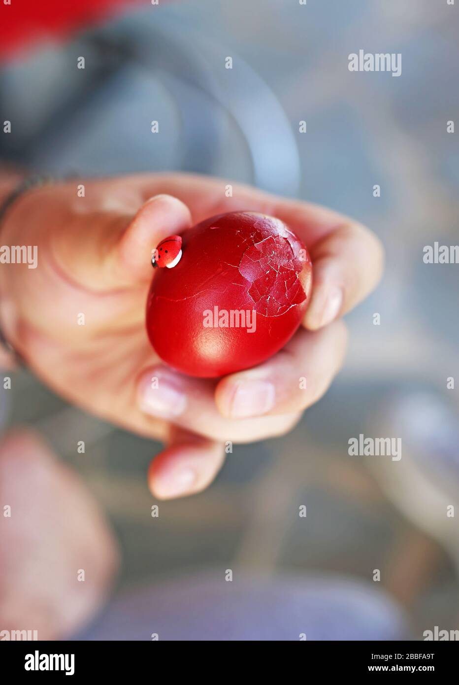 hand holding a cracked red Easter egg Orthodox greek tradition of