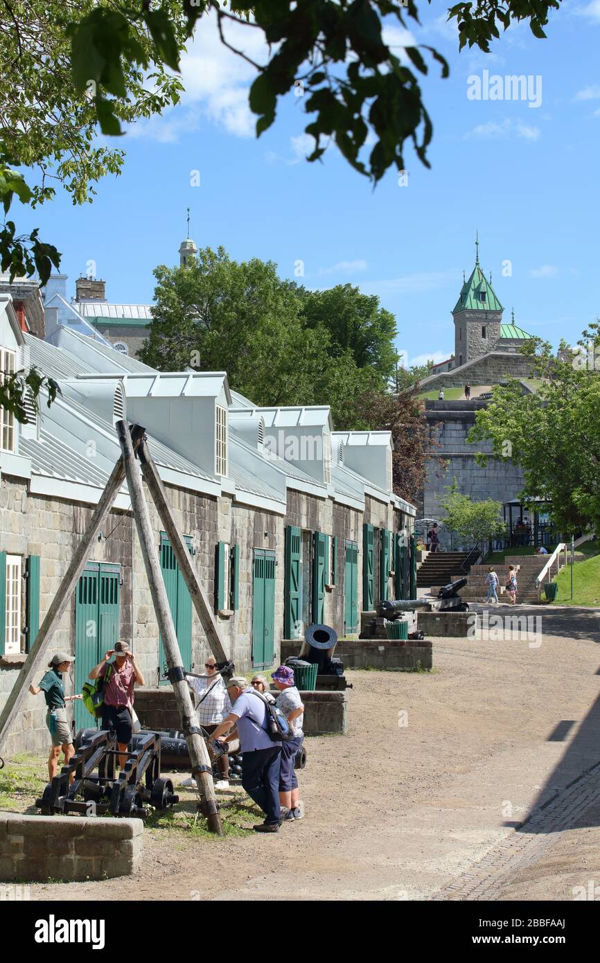 Canada Parks guide with group of tourists in front of the ordinance storehouse at the Artillery Park. In the background are Porte Saint-Jean (St. John Gate) and the Fortifications of Quebec, Upper Town, Old Quebec City, Province of Quebec, Canada Stock Photo