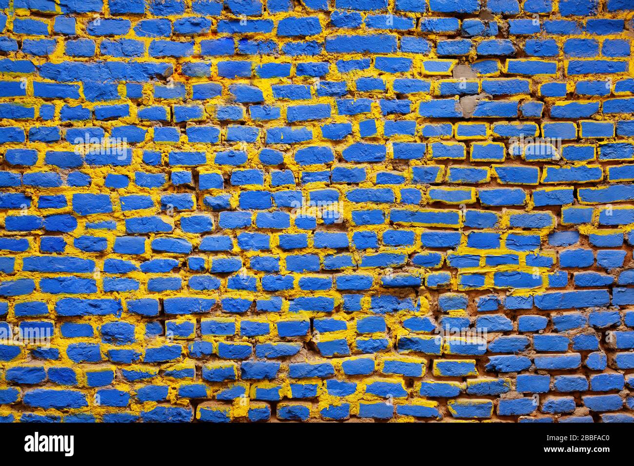 Brick wall painted in blue and yellow Stock Photo