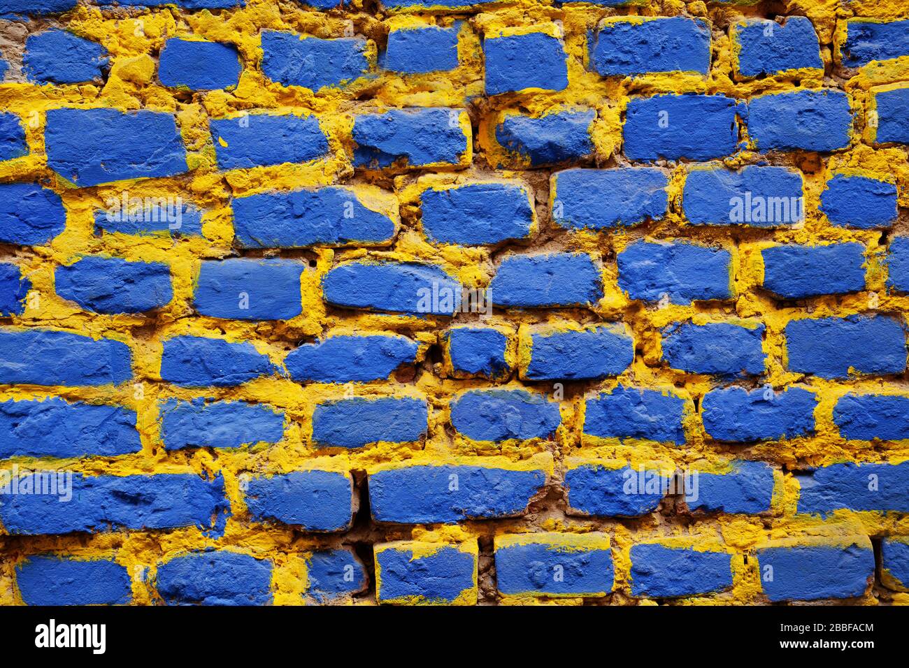 Brick wall painted in blue and yellow Stock Photo