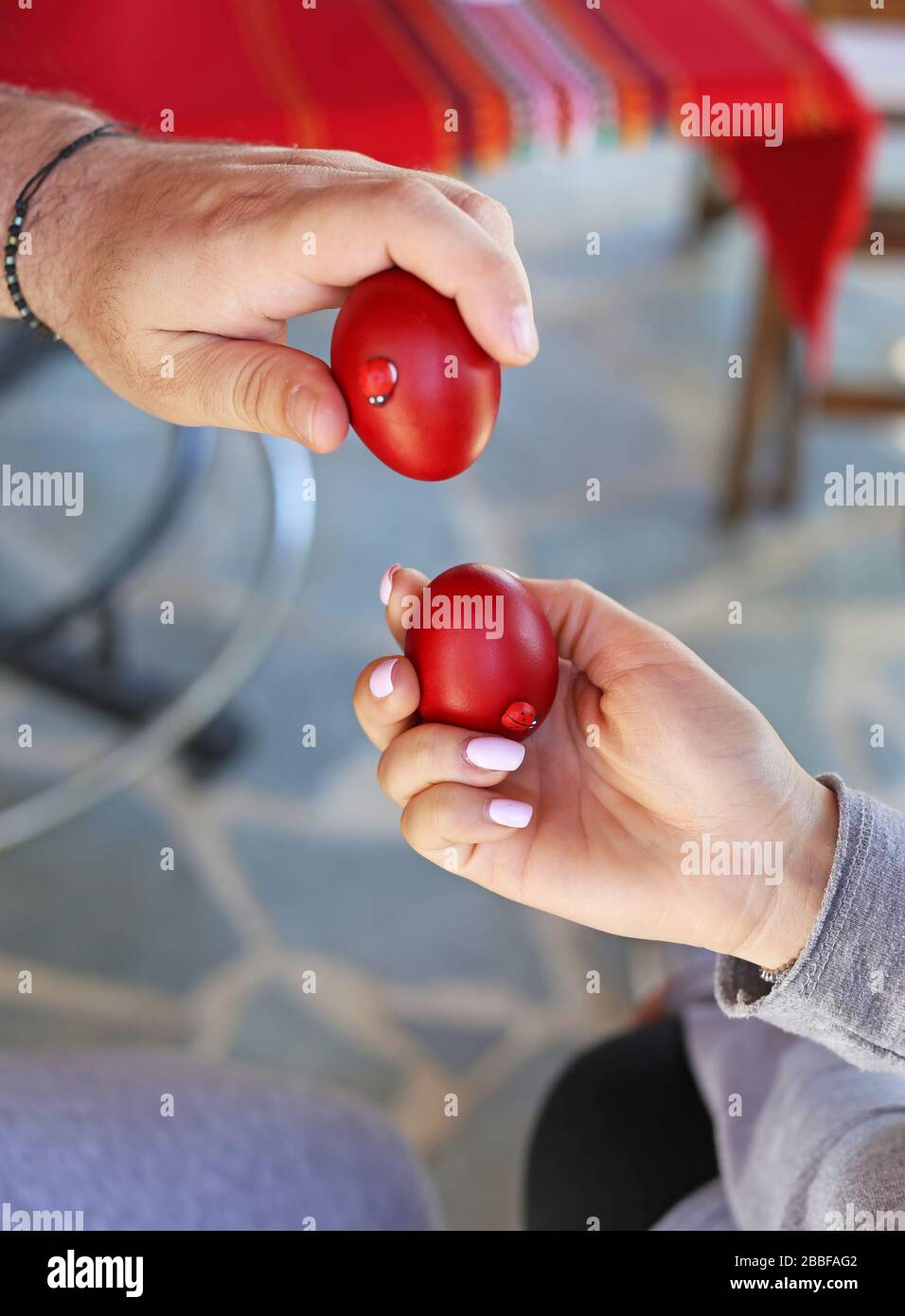 hands holding cracked red Easter eggs Orthodox greek tradition of