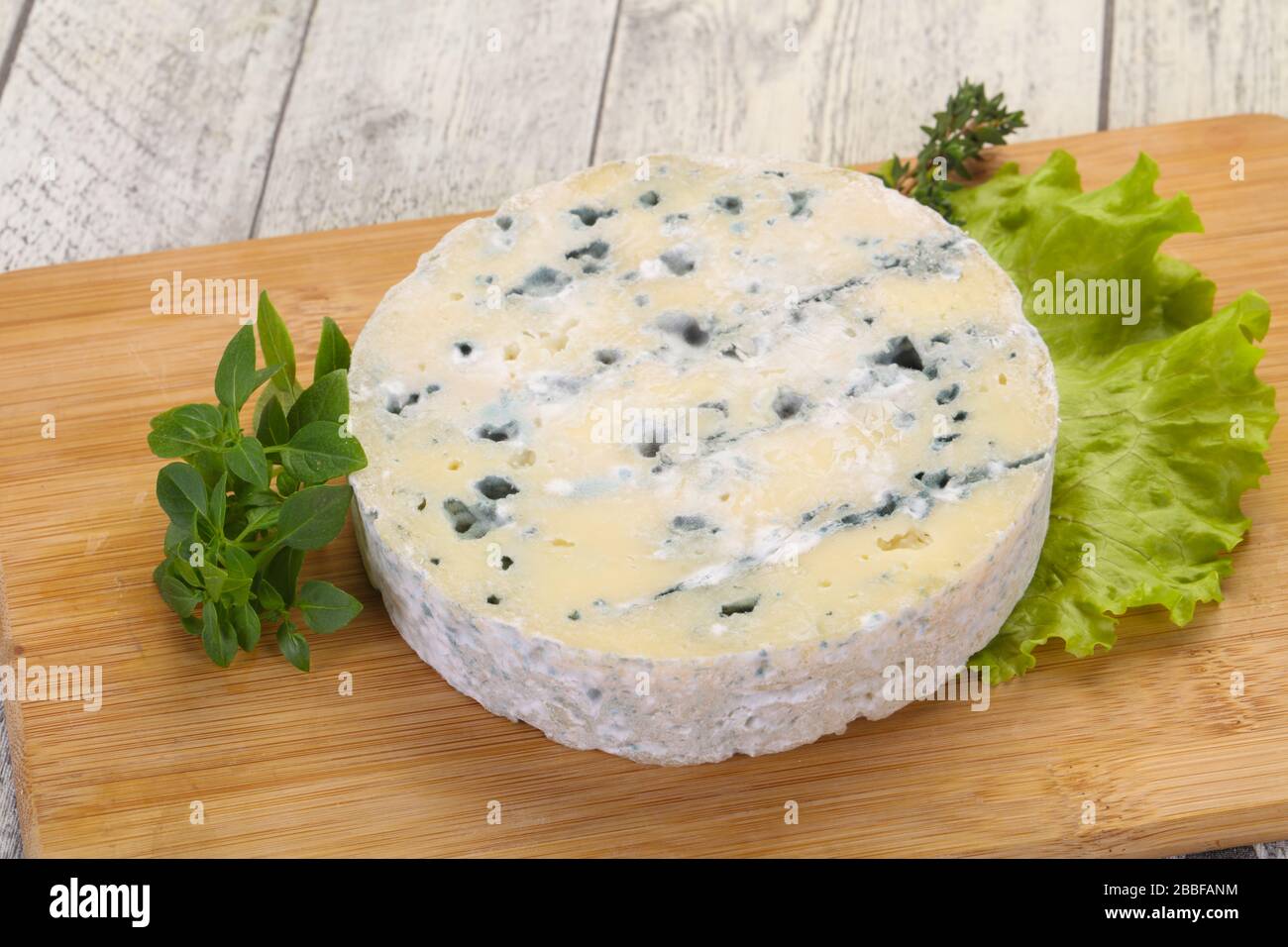 Round blue cheese with salad and basil Stock Photo Alamy