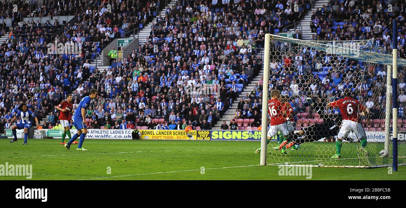 Wigan Athletic's Roger Espinoza (far left) scores the opening goal past Swansea City's goalkeeper Michel Vorm. Stock Photo