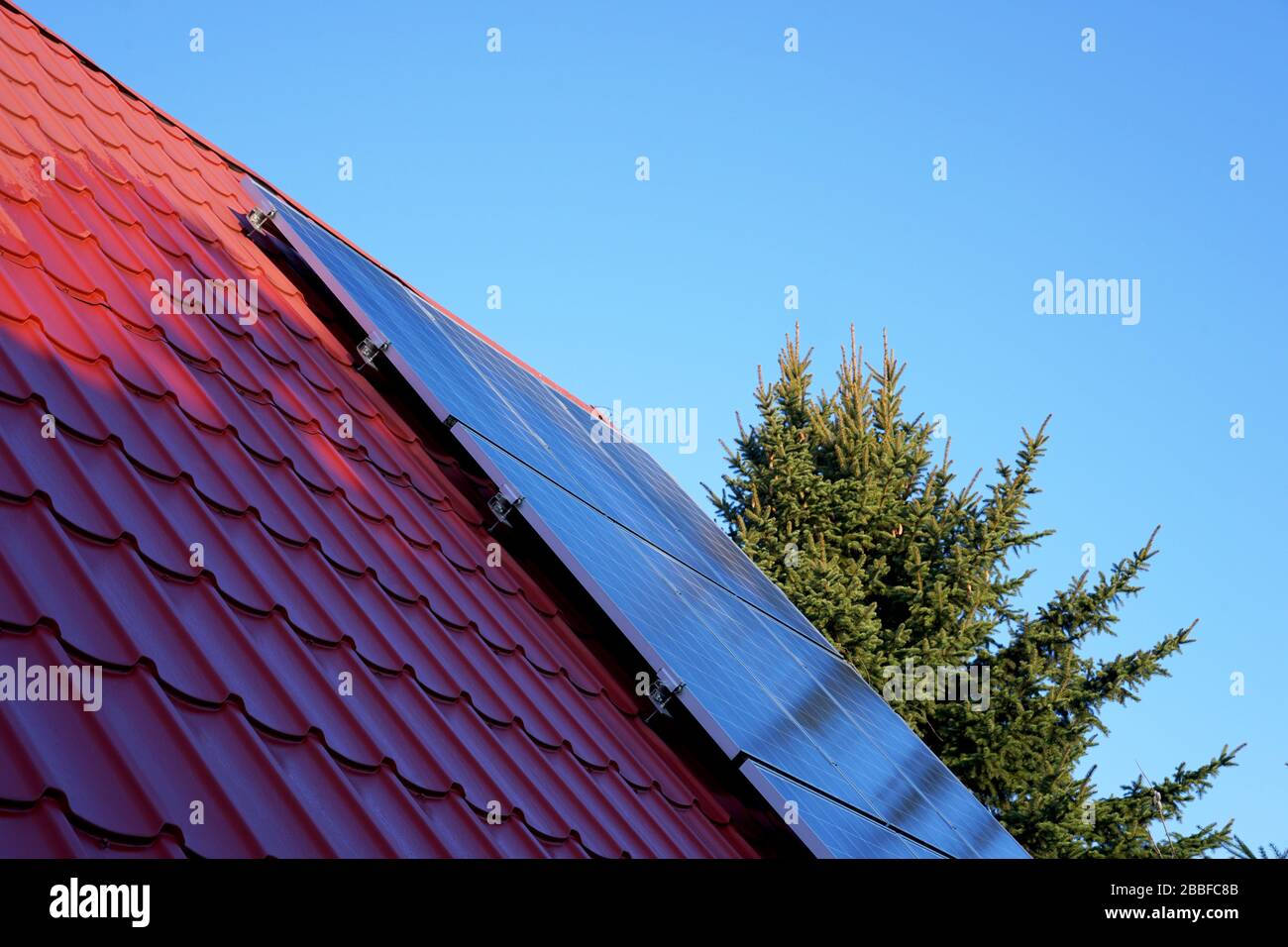 photovoltaic panels on the roof with shadow of a single-family house in the countryside Stock Photo