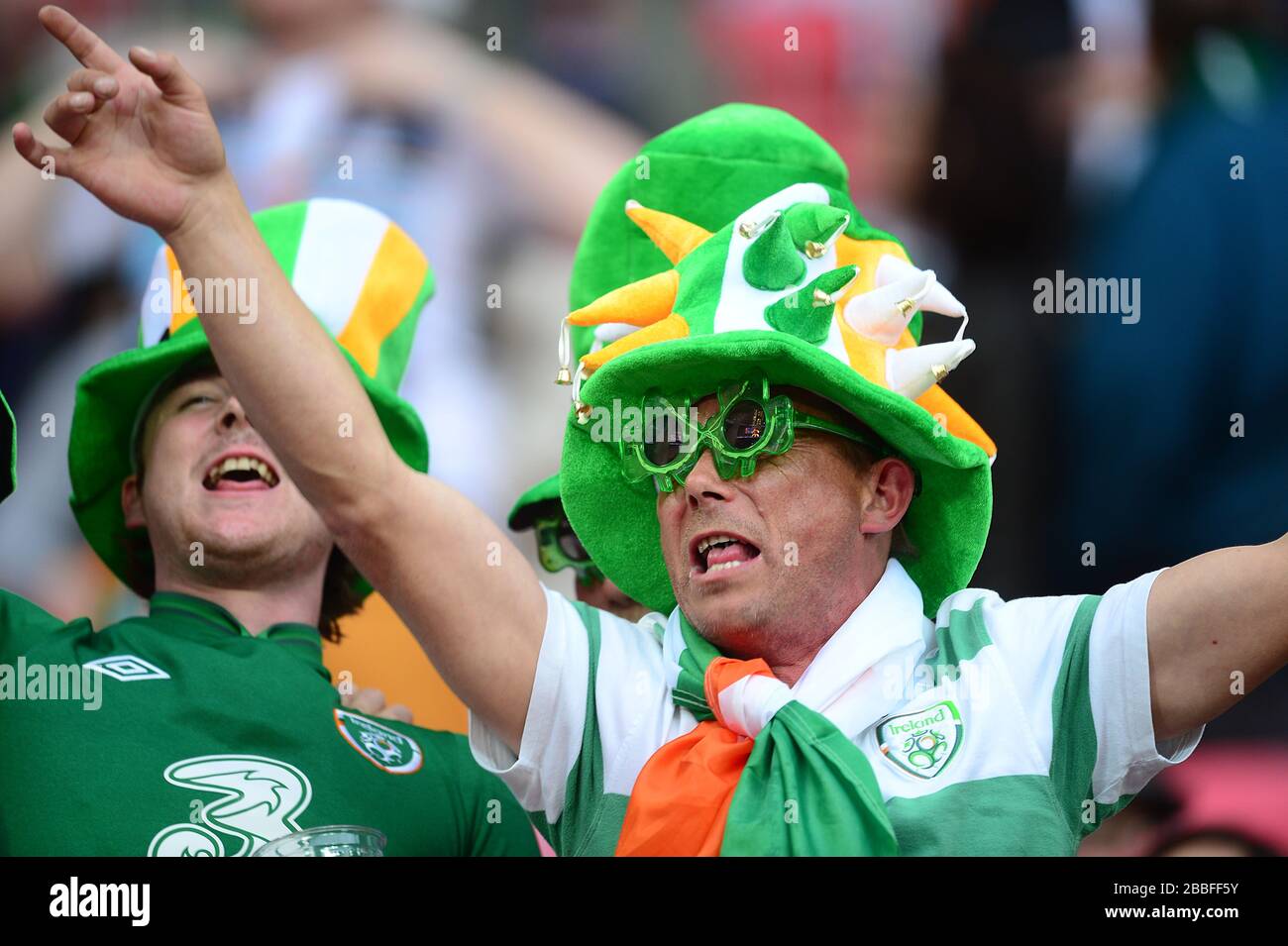 A Republic of Ireland fan wearing a jester hat and comedy glasses in the stands Stock Photo