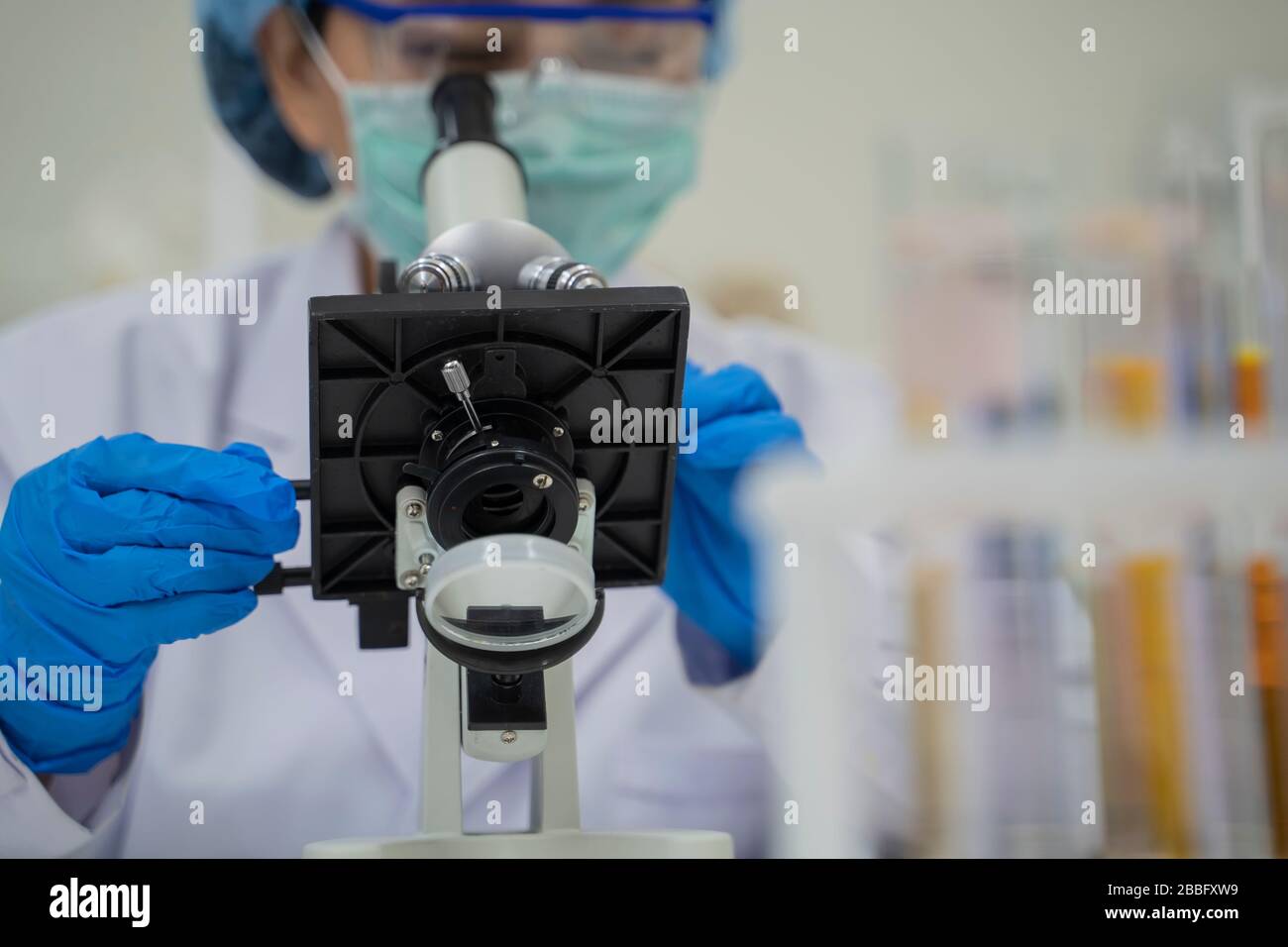 Scientists work and look at microscopes in laboratories to develop vaccines against viruses. Stock Photo