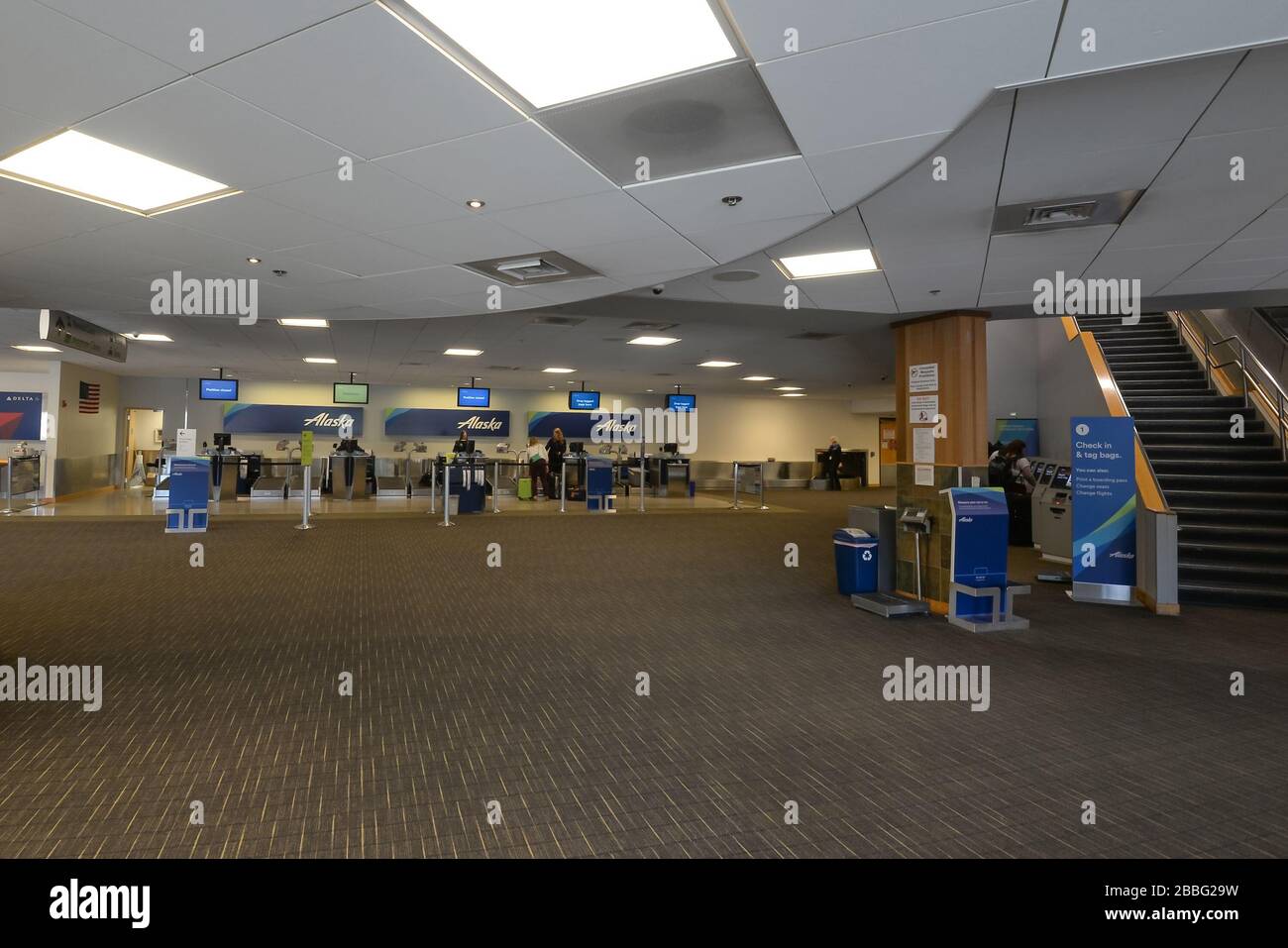 Interior view of Juneau International Airport passengers terminal with Alaska Airlines check-in desks in sight. Airport hall with carpet. Alaska, USA. Stock Photo