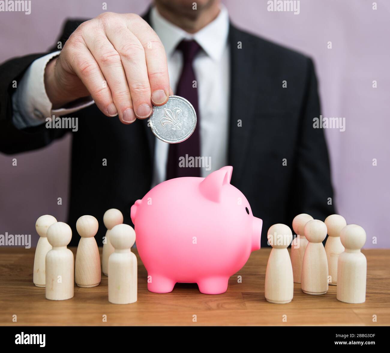 A business concept of a businessman paying into an employee salary, pension, tax, bonus or incentive scheme Stock Photo