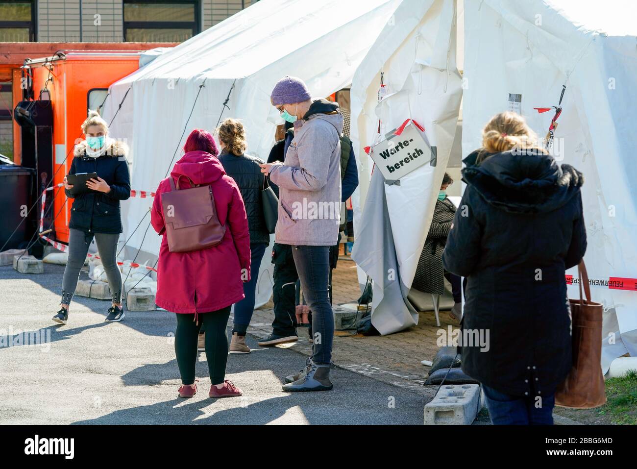 Dortmund, 31.3.2020: Am Klinikum Nord in Dortmund gibt es ein Corona-Testzentrum. In Zelten und Containern können Menschen auf das Virus untersucht werden. Foto: Personen warten auf den Test.   ---   Dortmund/Germany, March 31, 2020: Corona test center at the Klinikum Nord (Clinic North) in Dortmund/Germany. In tents and containers People can be examined for the virus. Photo: People are waiting for the test. Stock Photo