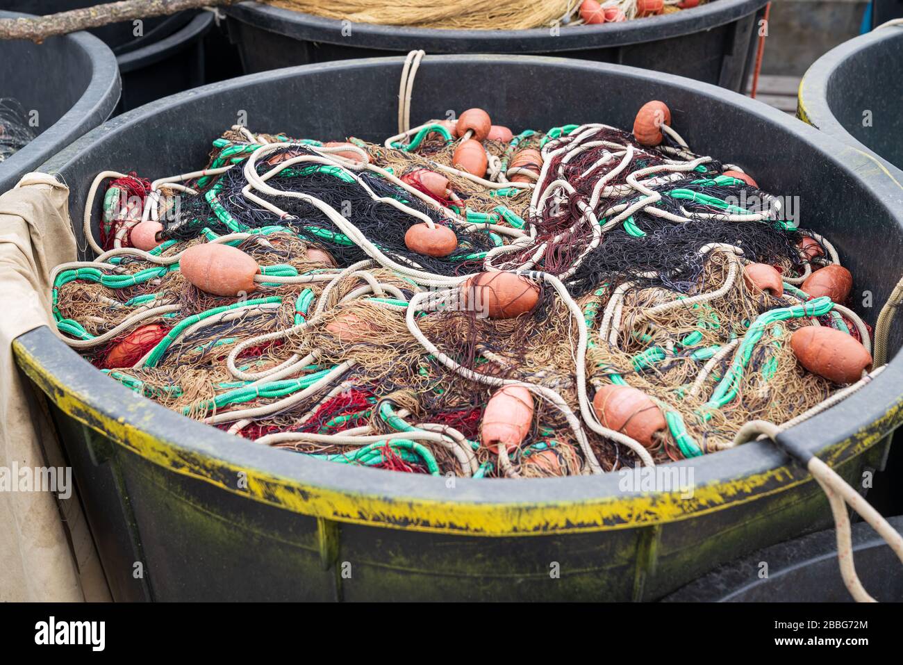 Fishing nets inside huge plastic bin on the waterfront after fishing