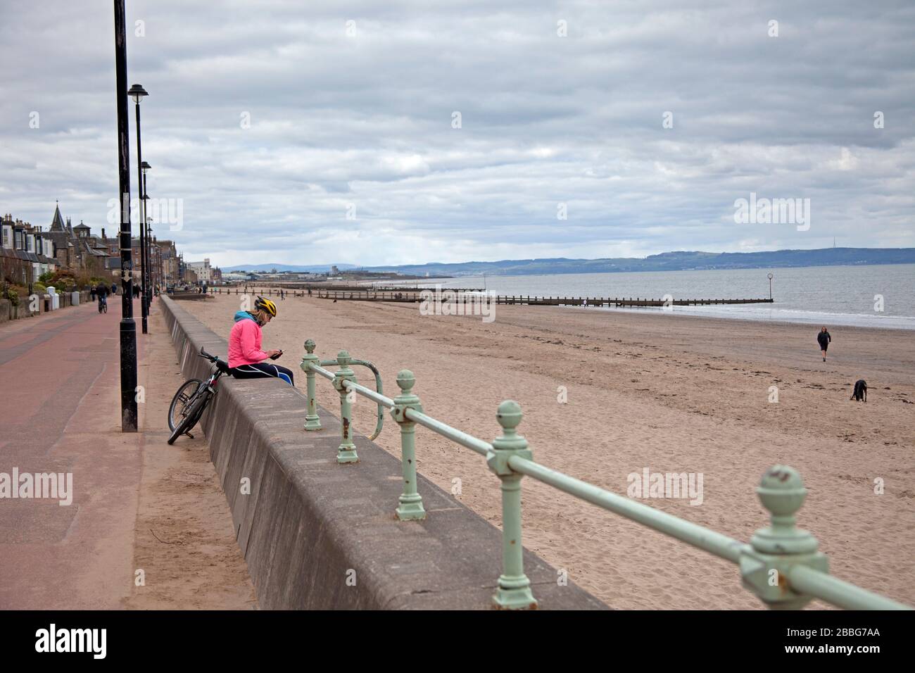 Portobello, Edinburgh, Scotland, UK. 31st Mar 2020. Cloudy and quiet on the promenade and beach rather than the crowds that normally frequent on an afternoon, with possibly around 200 people the length of the beach. More like winter time than spring time with Amusement arcades and coffe stalls closed together with the Children's Playpark taped off forbidding anyone from entering due to the Coronavirus threat. Stock Photo