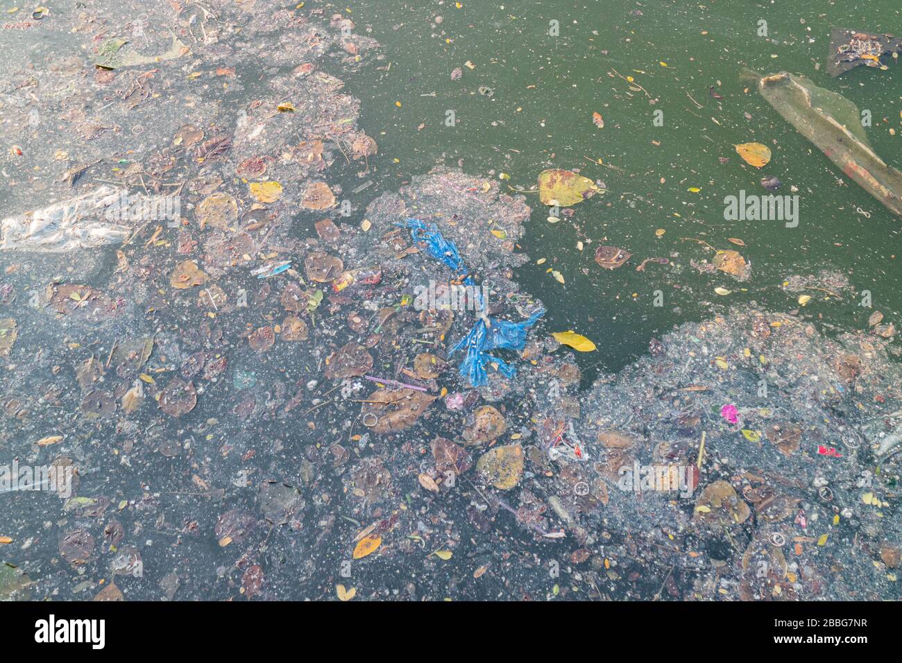 Grease and plastic waste floating on the surface of the water caused by