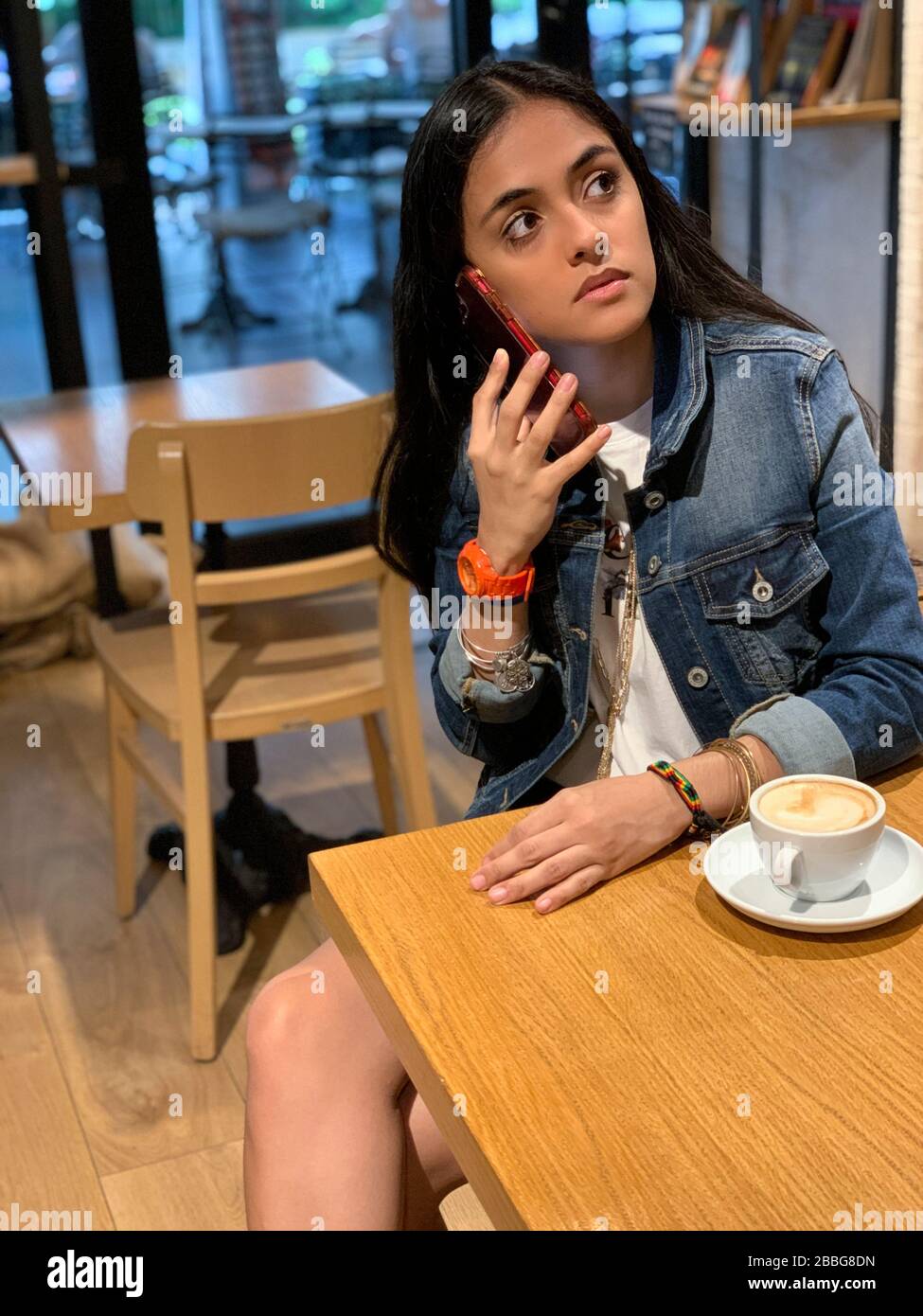 Girl with a Cup of coffee on a wooden table in the cafe, Panama city, Central America Stock Photo