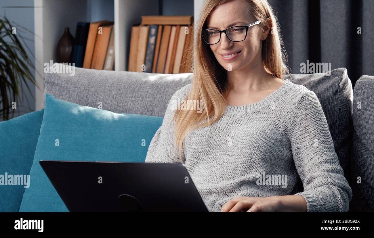 Woman using laptop on couch Stock Photo