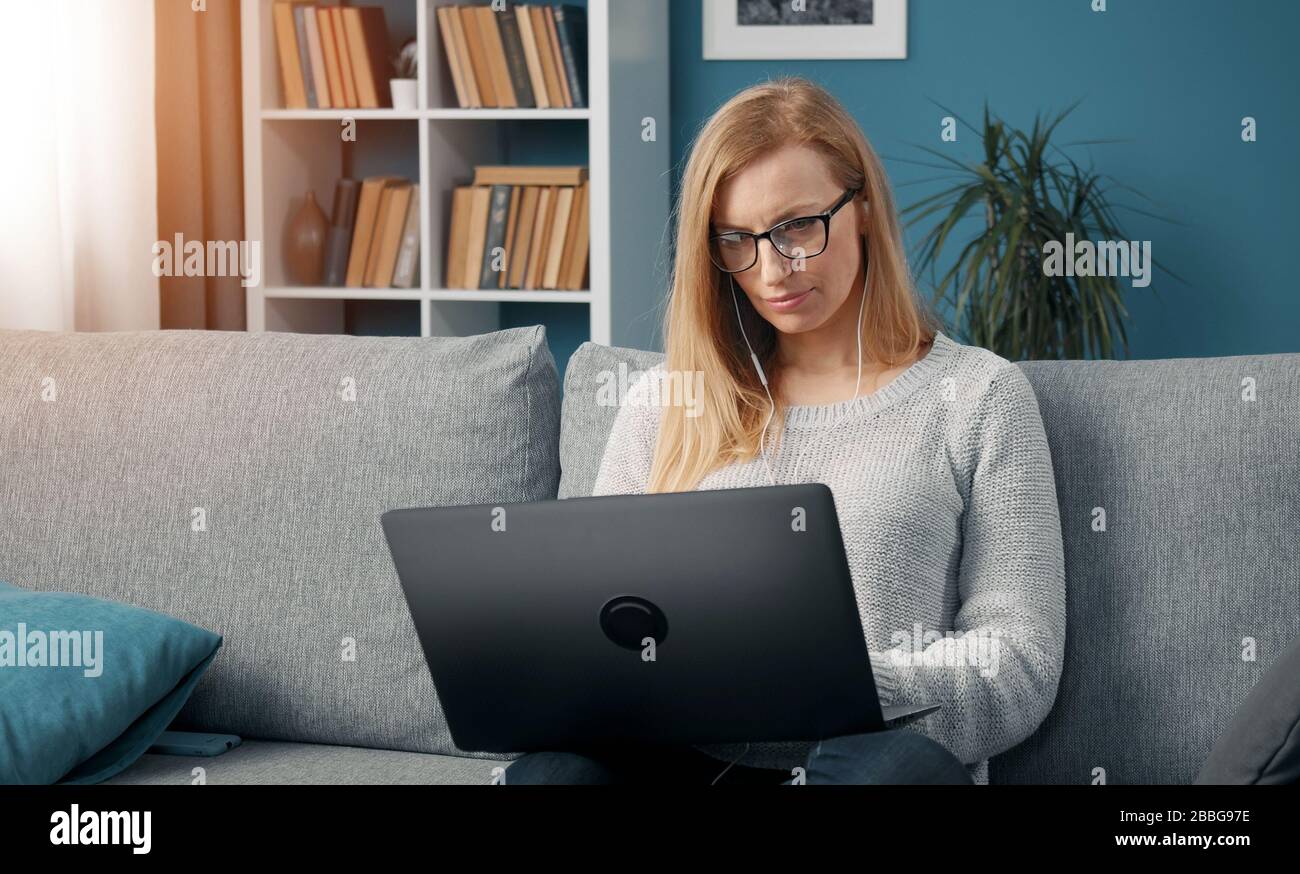 Blonde using laptop on sofa Stock Photo