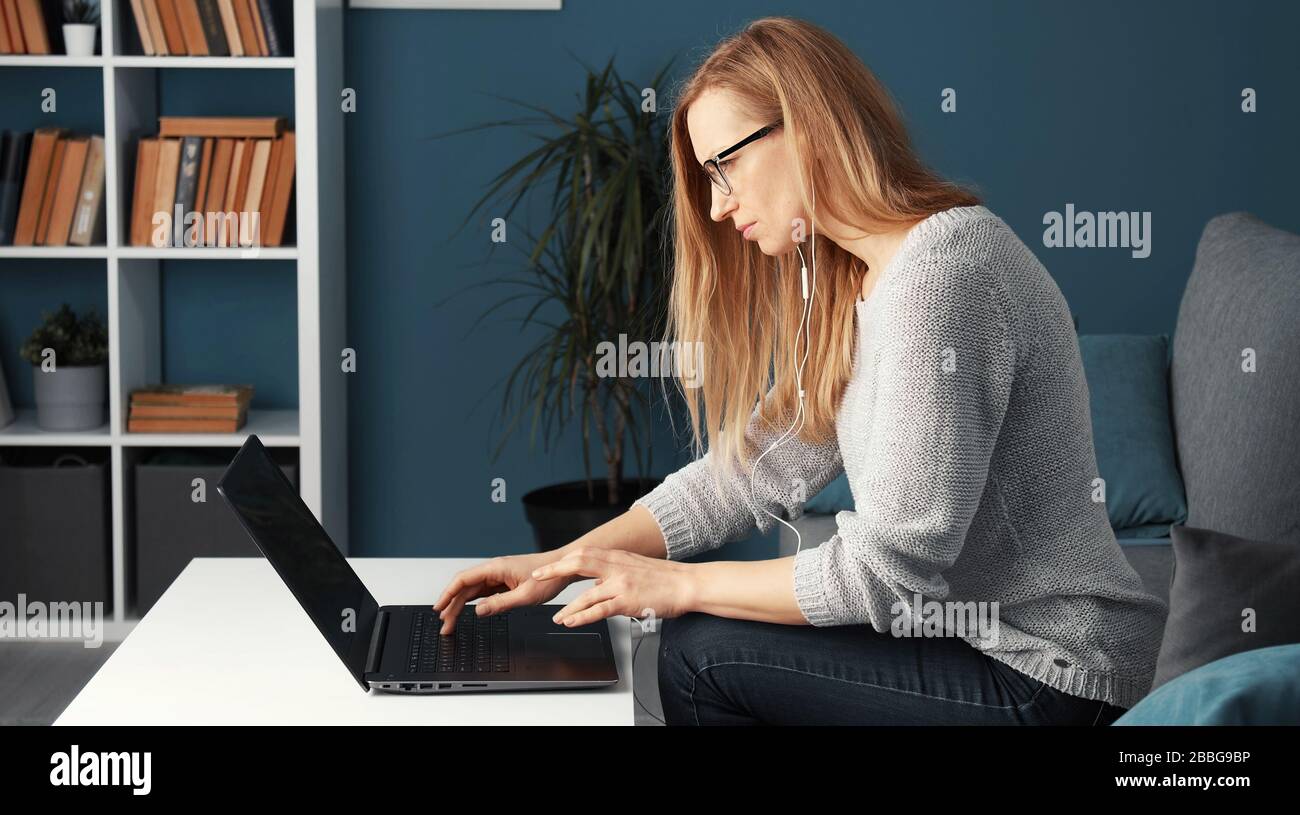 Woman working laptop sitting sofa Stock Photo