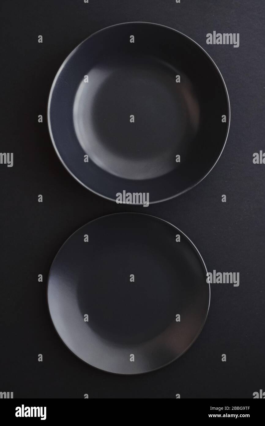 Empty plates on black background, premium dishware for holiday dinner ...