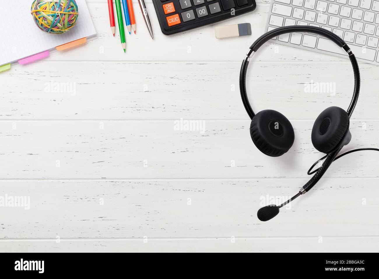 Office wooden workplace backdrop with supplies, headset, coffee and ...