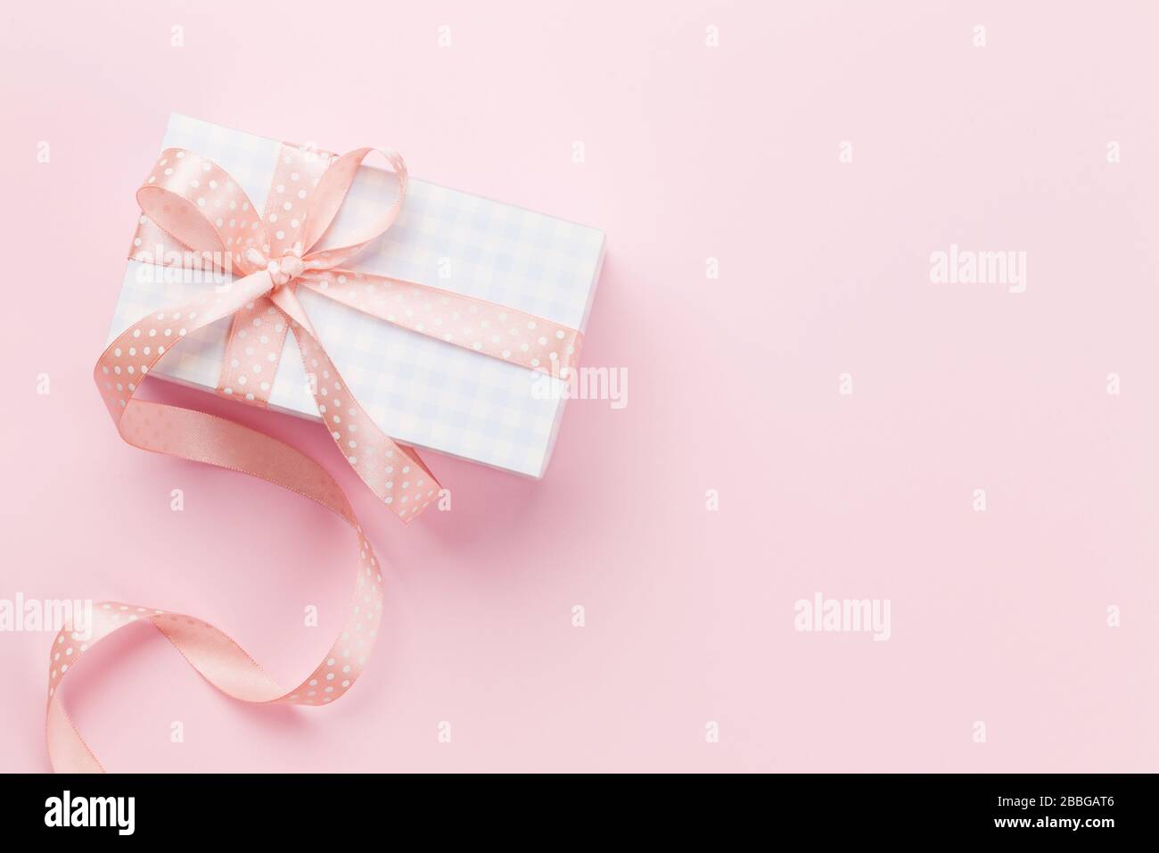 Greeting card with pastel color gift box on pink background. Top view ...