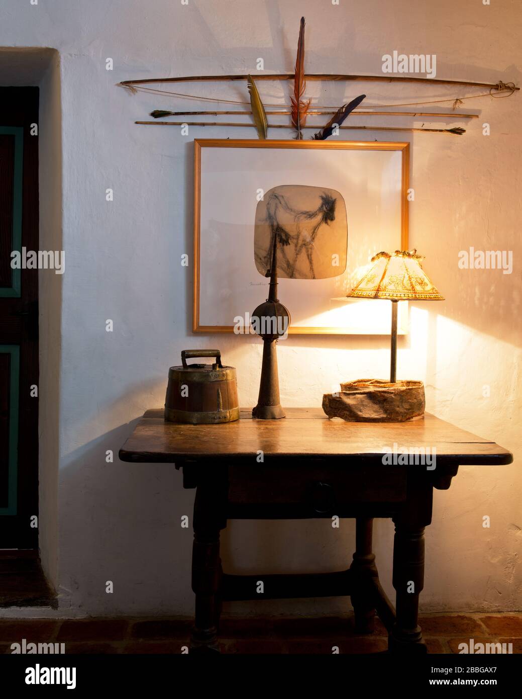 entrance hall table with table lamp, framed picture and African bow and