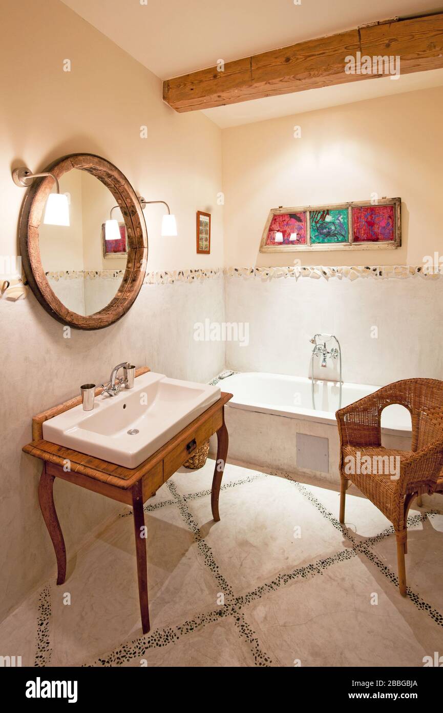bathroom with bathtub, sink, artwork and chair Stock Photo