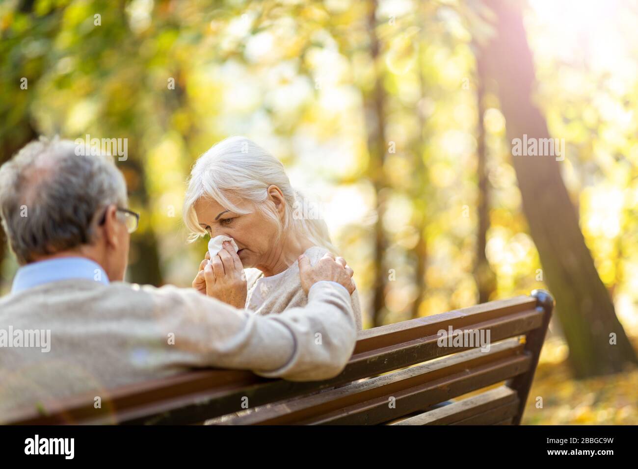 Depressed senior woman consoled by elderly man Stock Photo