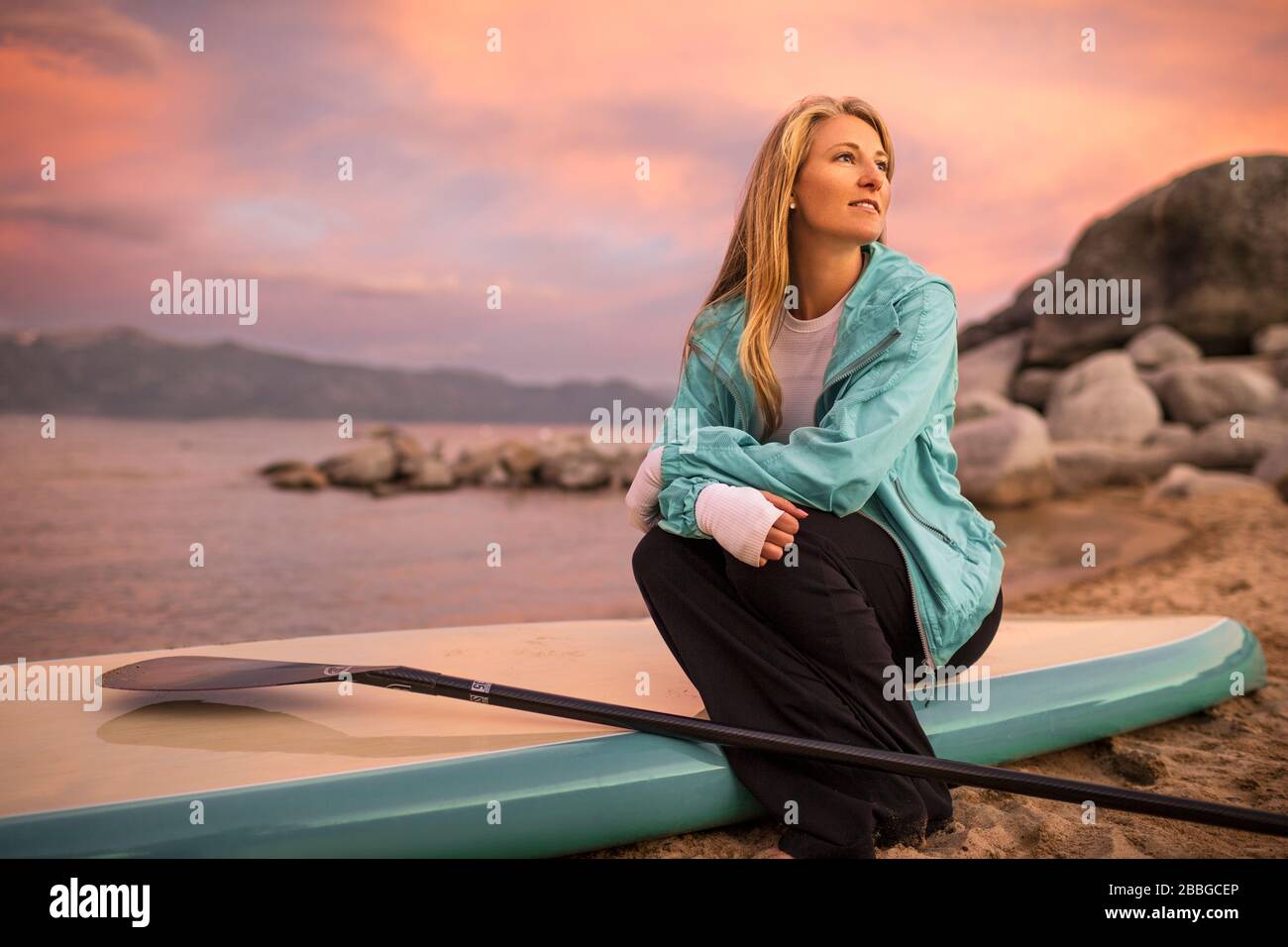 Young woman sitting on her paddle board Stock Photo