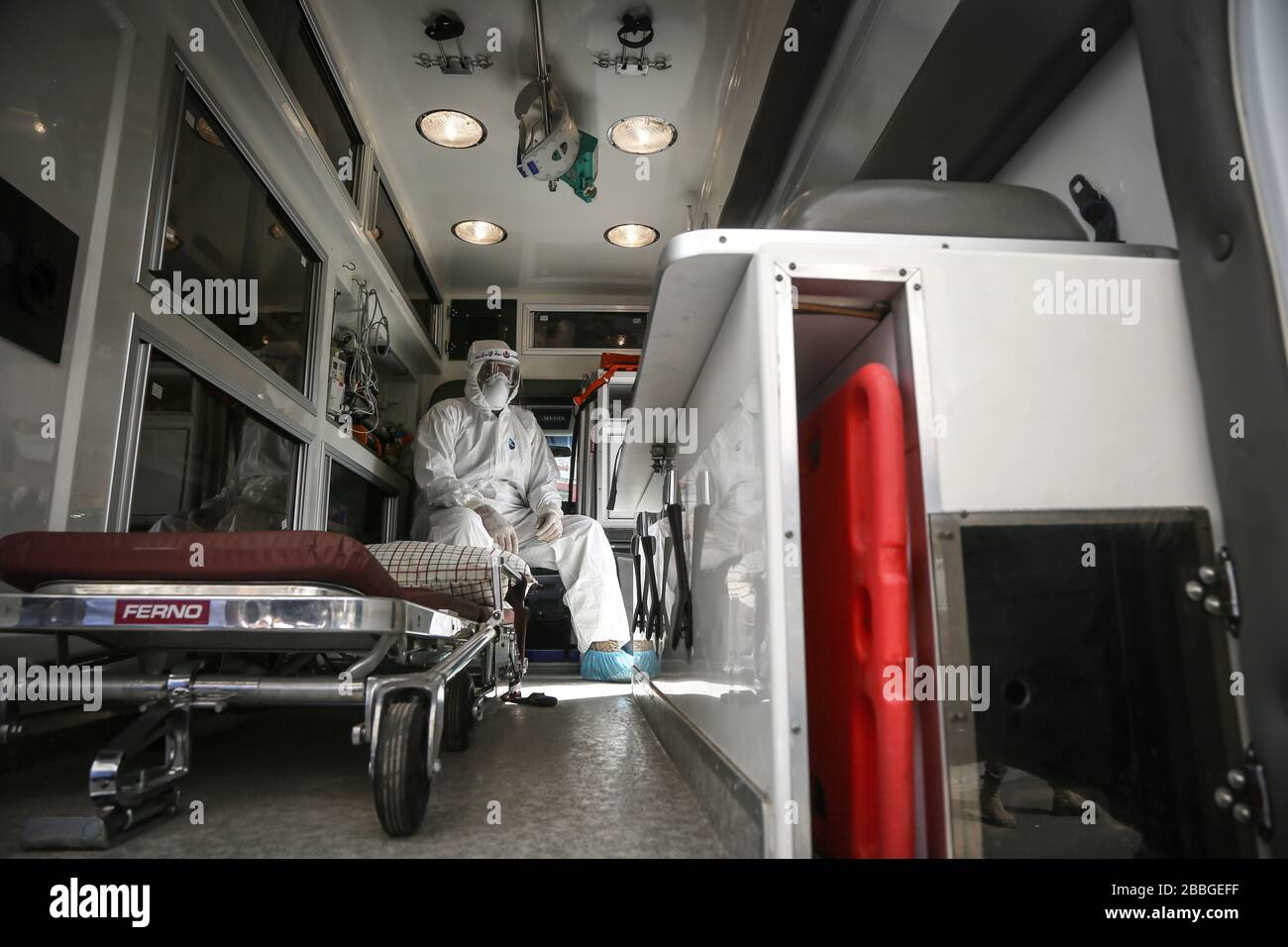 Beirut, Lebanon. 31st Mar, 2020. A member of the medical apparatus of the pro-Iranian party Hezbollah, is seen wearing full protective gear inside an ambulance during a street show to demonstrate readiness for the coronavirus battle. Hezbollah is mobilizing thousands of front line medics and readying field hospitals as well as carrying disinfection works at the Lebanese streets to help confront the coronavirus pandemic. Credit: Marwan Naamani/dpa/Alamy Live News Stock Photo