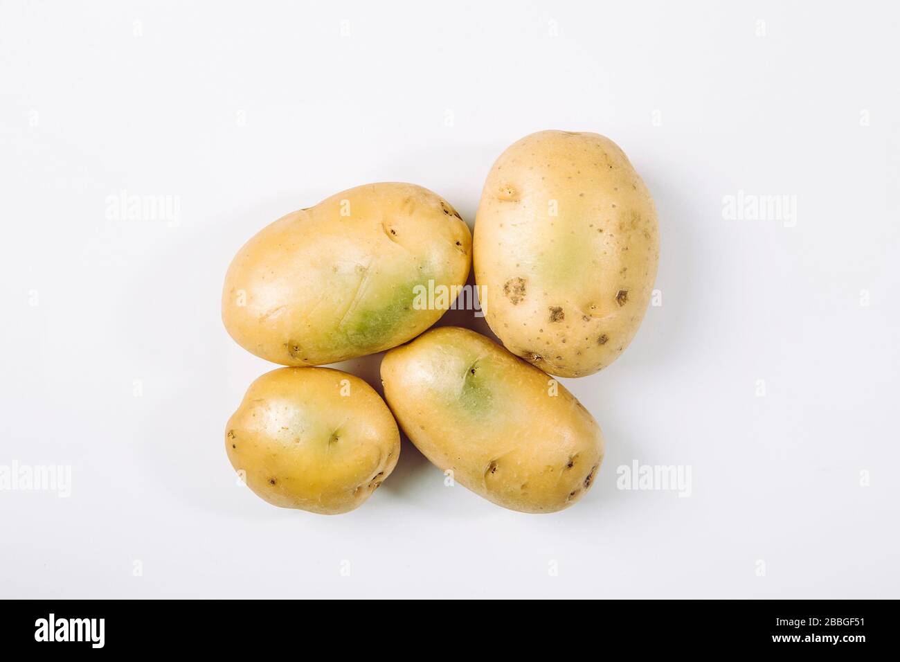 Sunlight and warmth turn potatoes skin green witch contain high levels of a toxin, solanine which can cause sickness and is poisonous. Do not buy and Stock Photo