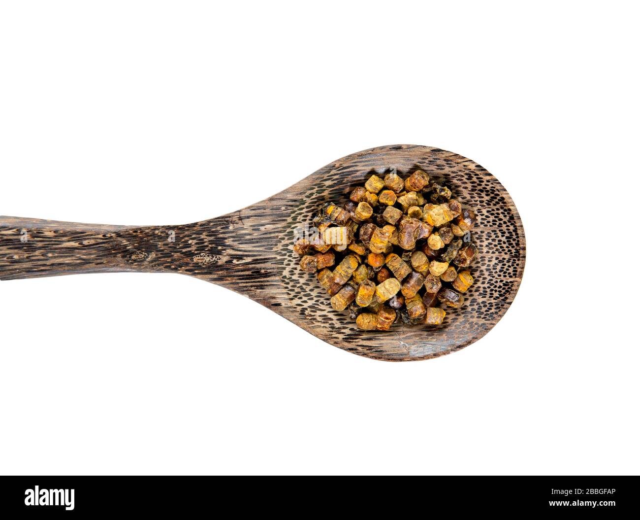 Fermented bee bread also known as fermented bee pollen on wood spoon isolated on white background. Alternative medicine concept. Stock Photo