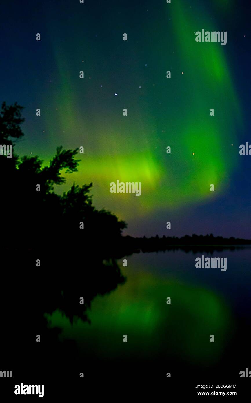 Aurora dancing over water in Lake Winnipeg, Manitoba Canada Stock Photo