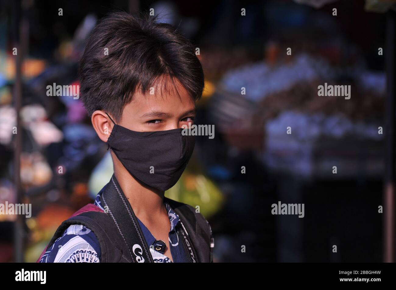 Mixed race boy (Cambodian American) wearing a face mask at Kandal