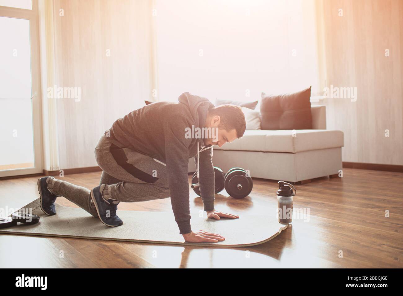 Young ordinary man go in for sport at home. Picture of real ordinary man doing abs exercising by running on one place with legs. Worksout freshman Stock Photo Alamy