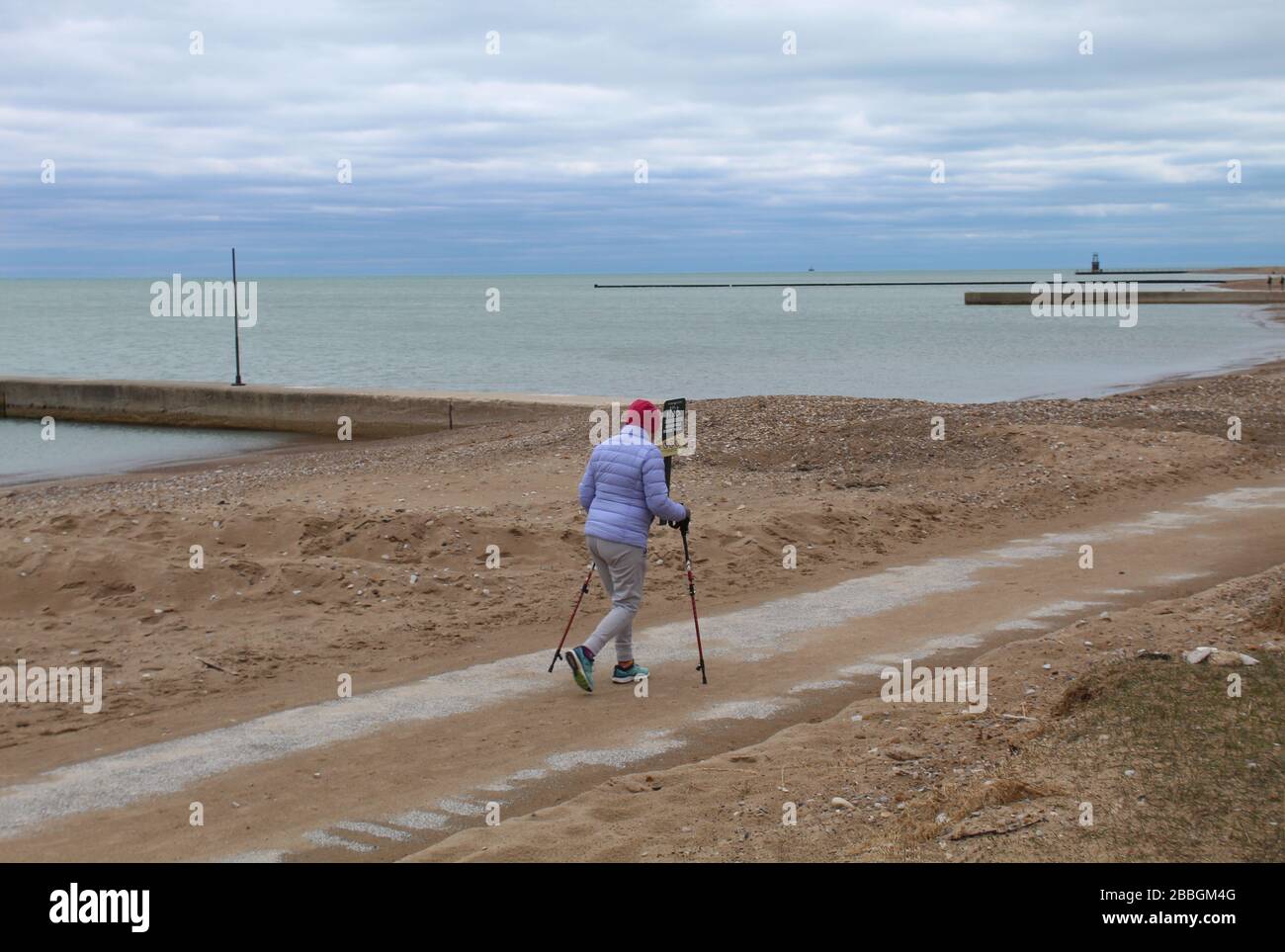 Woman with two walking canes on a beach path at Loyola Park in Chicago at Lake Michigan Stock Photo