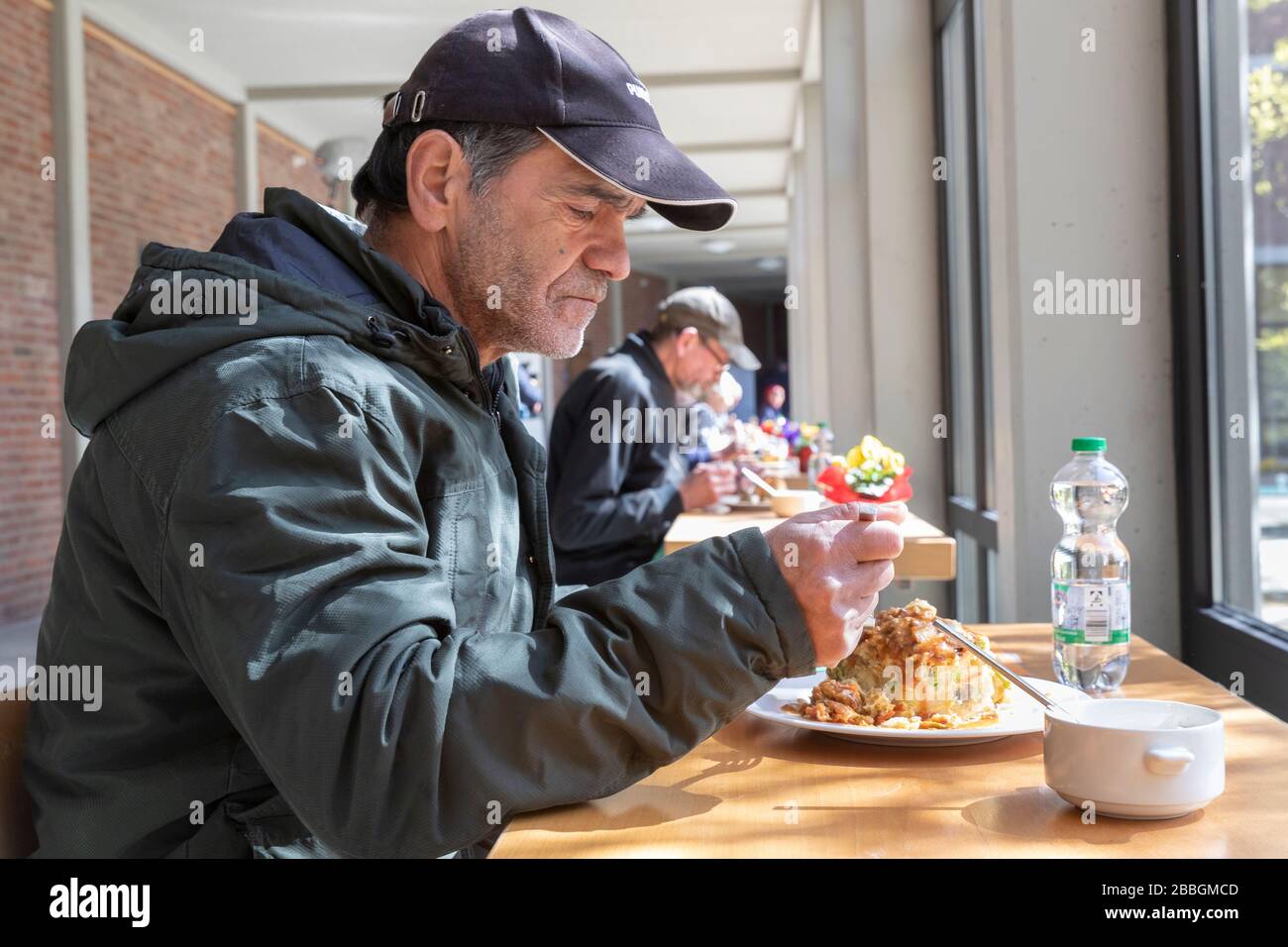 Hilfsangebote des Erzbistums Koeln fŸr Obdachlose im Erzbischoeflichen Priesterseminar in der aktuellen Corona-Pandemie  Obdachloser beim Mittagessen Stock Photo