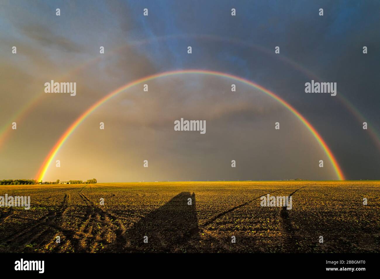 End of storm double rainbow over field in southern Manitoba Canada Stock Photo