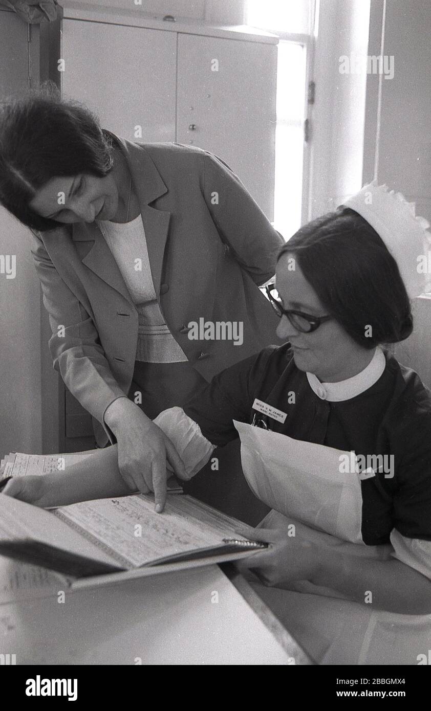 1970s, historical, a female Doctor with nurse sister looking at a patient's medical notes, Lewisham, South East London, England, UK. Stock Photo