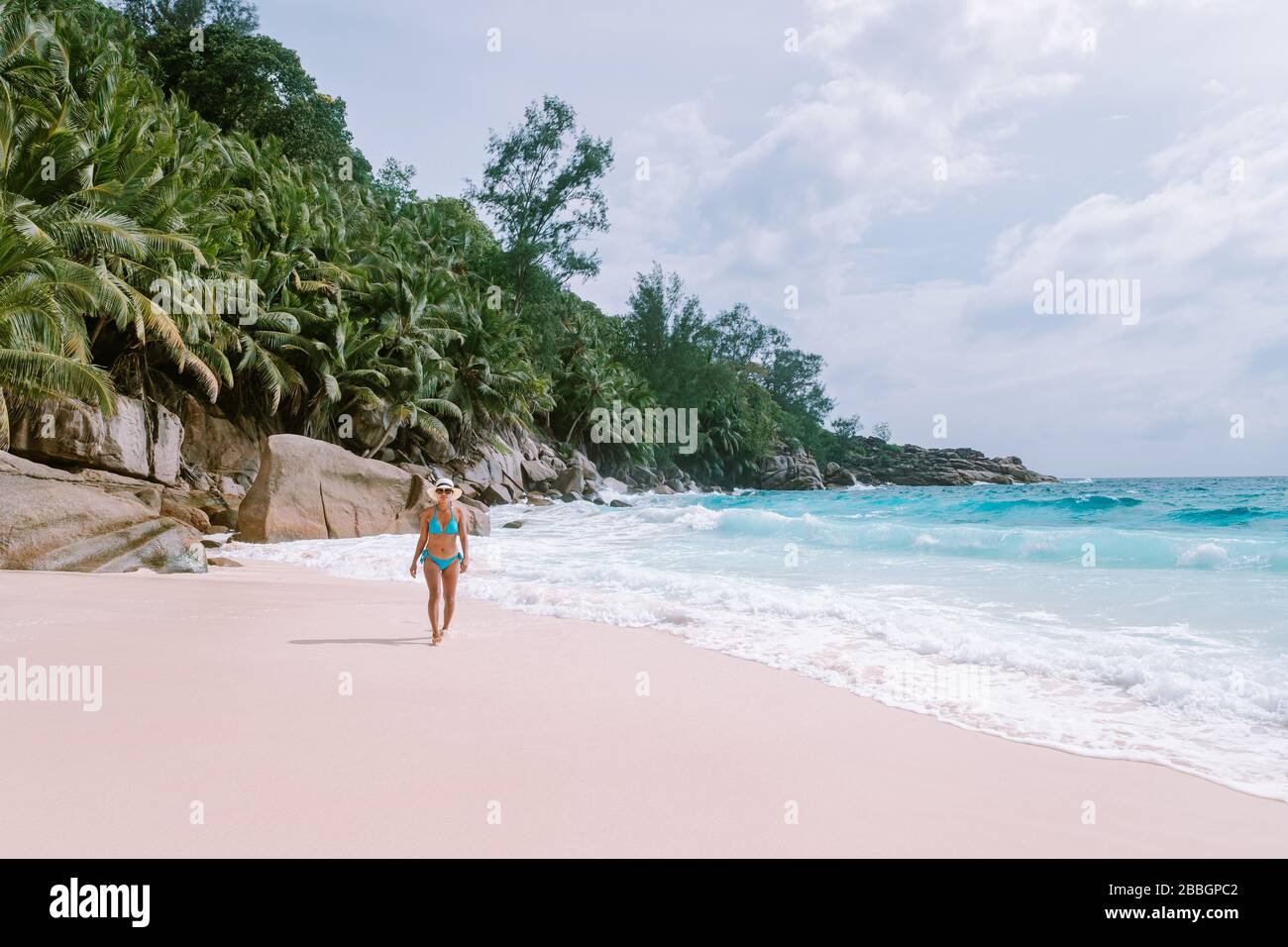 Petite Anse Mahe Seychelles, young woman on the beach, mid age Asian woman walking on tropical beach Seychelles Stock Photo