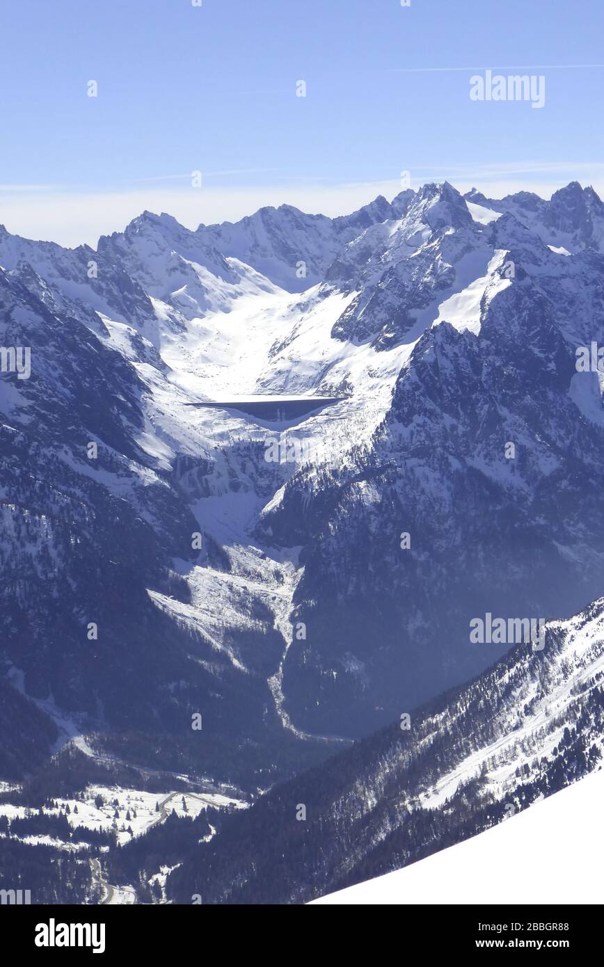 Bivio, Skitour auf den Piz dal Sasc. Blick vom Gipfel auf Albigna- Stausee mit Bergeller Berge. Stock Photo